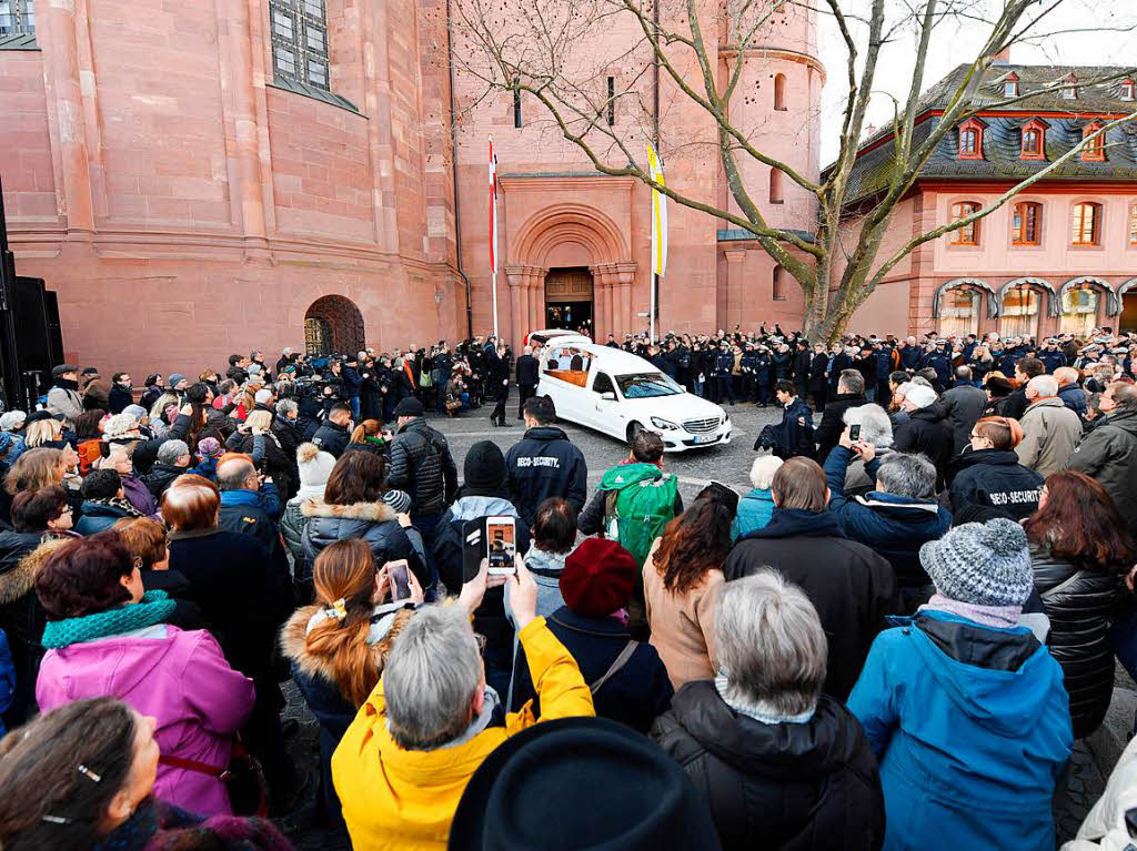Viele Menschen haben sich vor der Bischofspforte des Mainzer Doms versammelt, um dem Verstorbenen die letzte Ehre zu erweisen.
