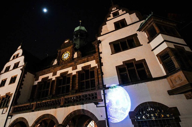 Eine Weltkugel wird bei der Klimaschut...uchtete Freiburger Rathaus projiziert.  | Foto: dpa