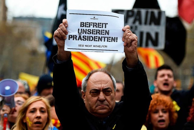 Ein Demonstrant hlt in Barcelona ein  Plakat in deutscher Sprache hoch.  | Foto: AFP