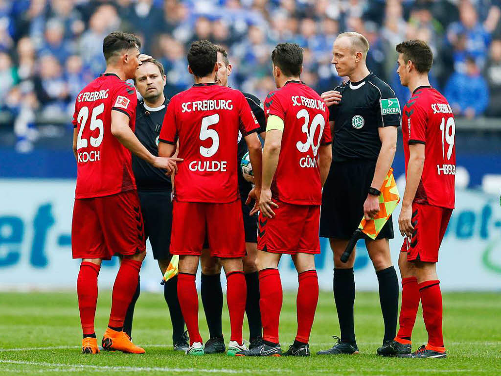 Nach dem Spiel unterhalten sich die Spieler mit dem Schiedsrichtergespann.