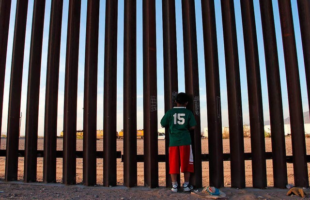 Ein mexikanisches Kind in Ciudad Juare...e am Zaun zwischen Mexiko und der USA.  | Foto: AFP