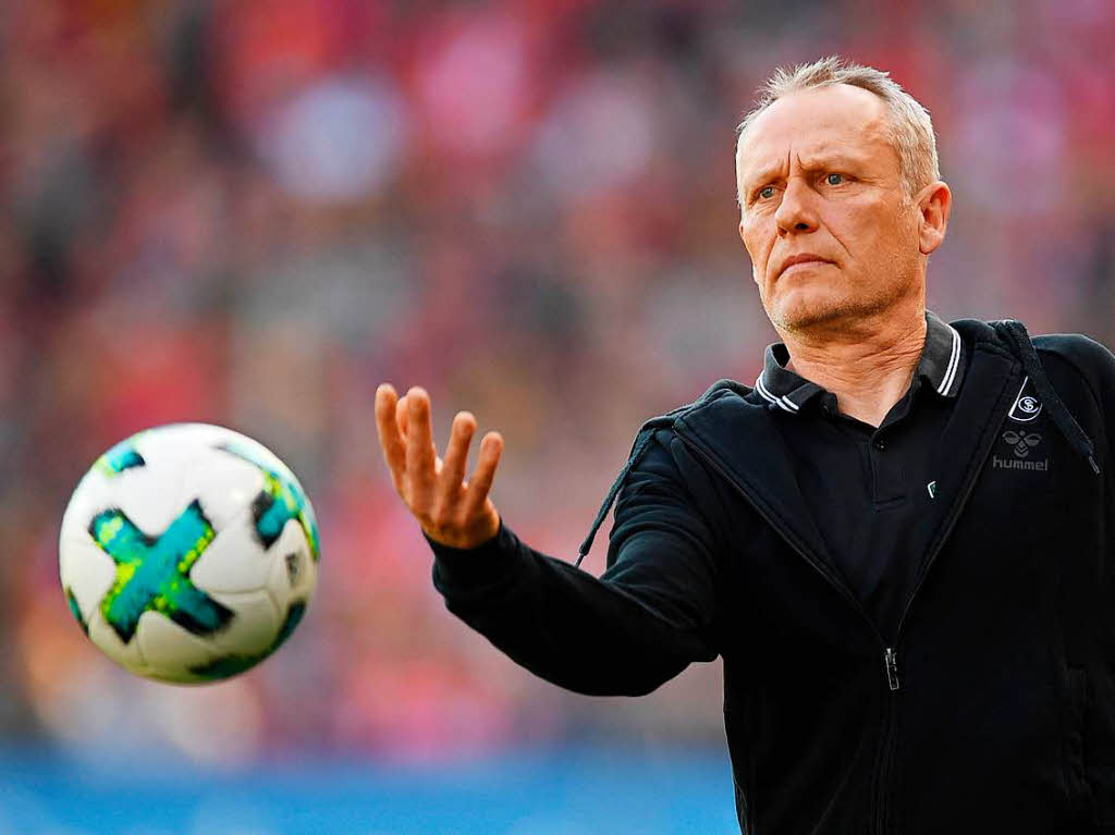 Einwurfhilfe: Christian Streich gibt den Ball her.