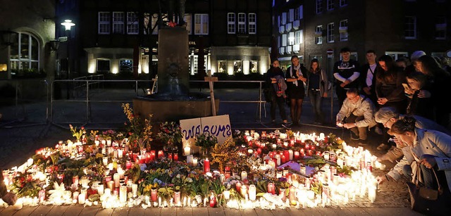Am Sonntagabend legen zahlreiche Mensc...0;-Denkmal am abgesperrten Tatort ab.   | Foto: AFP