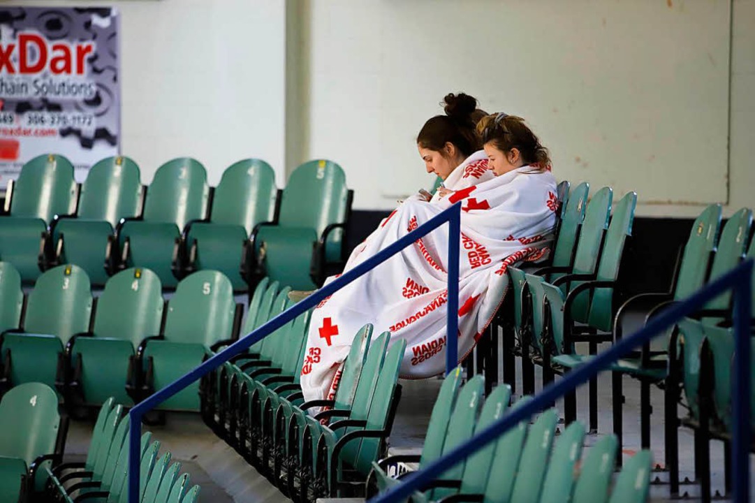Zwei trauernde Frauen im leeren Eisstadion von Humboldt  | Foto: afp