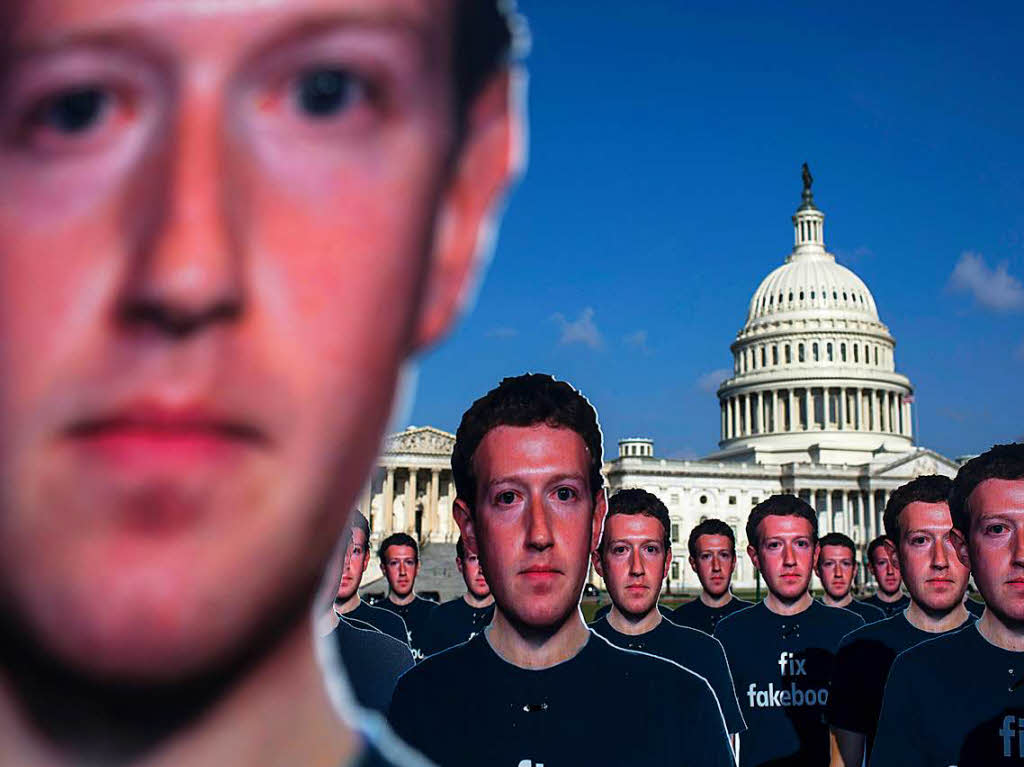 Aktivisten mit Mark Zuckerberg-Masken protestieren  vor dem Kapitol.
