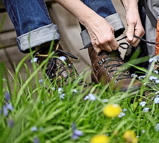 Ein Wanderer schnrt seine Schuhe.   | Foto: dpa