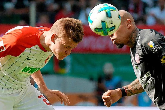 Augsburgs Alfred Finnbogason (l) und Nigel de Jong (Mainz) kmpfen um den Ball.  | Foto: dpa