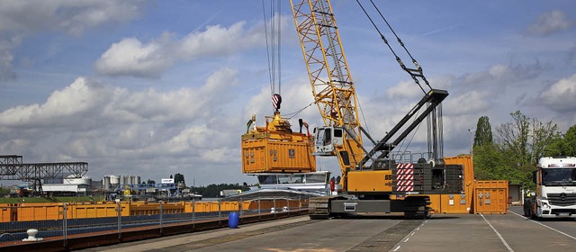 Lastwagen bringen die etwa 26 Tonnen s...ein Kran die Behlter auf das Schiff.   | Foto: Rolf Reissmann