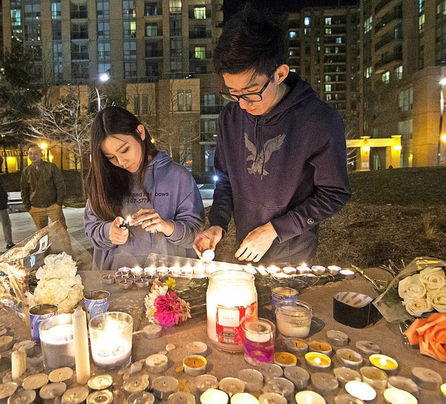 Menschen znden Kerzen an und legen Bl... des Unglcks in Toronto zu bekunden.   | Foto: dpa
