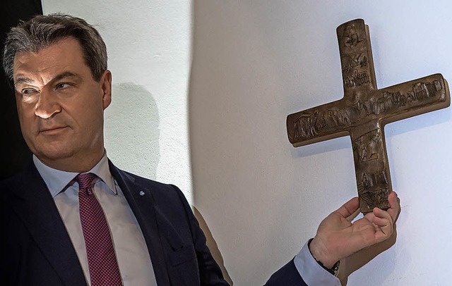 Markus Sder mit einem Kreuz in der bayerischen Staatskanzlei  | Foto: dpa