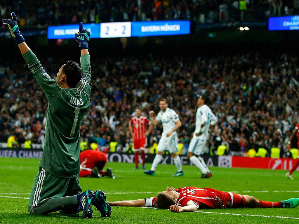 Madrids Torwart Keylor Navas (links) jubelt bei Schlusspfiff neben dem am Boden liegenden Münchner Thomas Müller. Madrids Torwart Keylor Navas (links) jubelt bei Schlusspfiff neben dem am Boden liegenden Münchner Thomas Müller.