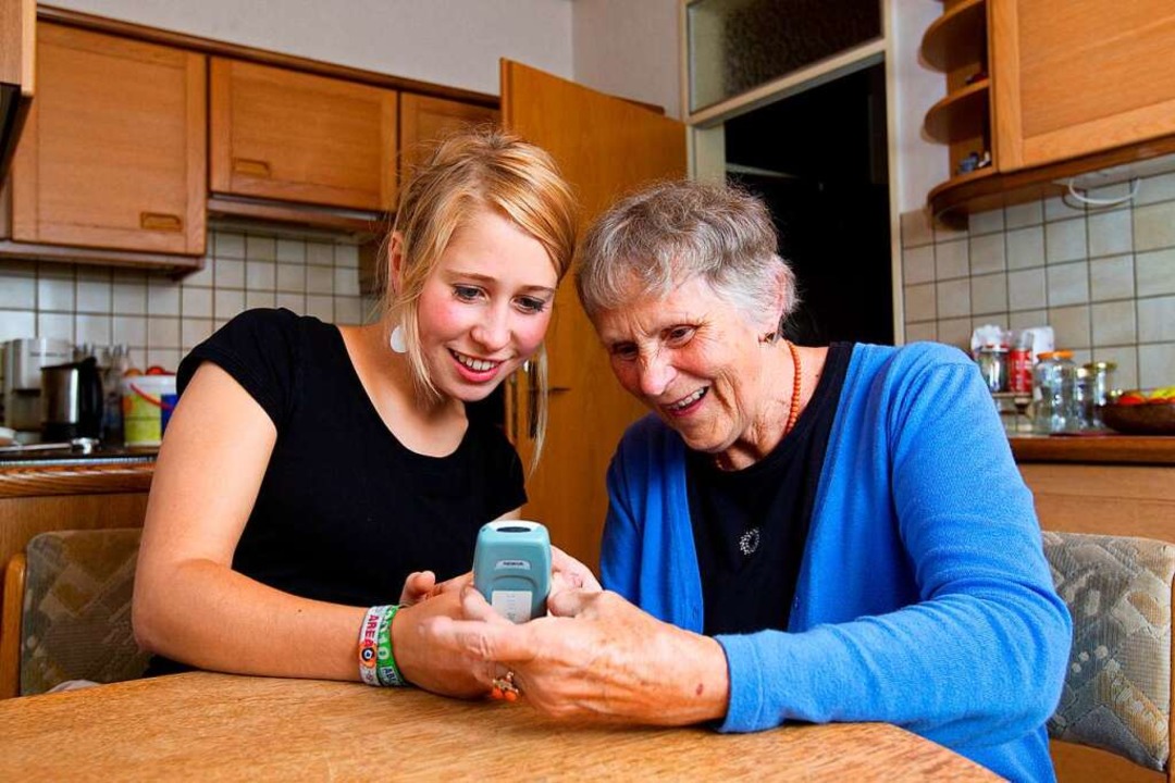 Jung und Alt wohnen zusammen: Eine Stu...r  Seniorin, wie man ein Handy bedient  | Foto: Friso Gentsch