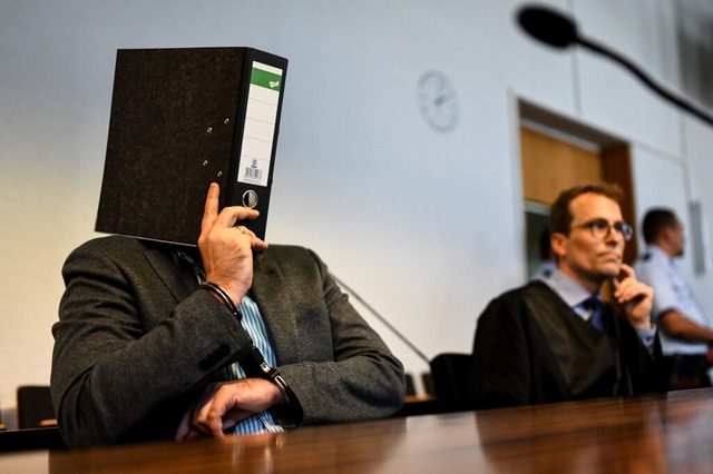 Knut S. verdeckt vor Prozessbeginn am ...r. Neben ihm sein Anwalt Holger Meier.  | Foto: dpa