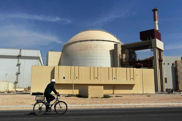 Ein Arbeiter fhrt mit seinem Fahrrad ... Atomkraftwerk Buschehr, Iran, vorbei.  | Foto: dpa
