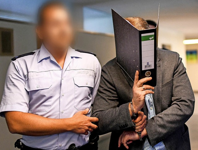 Ein Justizbeamter fhrt Knut S. an Han...fr den gesamten Prozess.  Vergeblich.  | Foto:  dpa