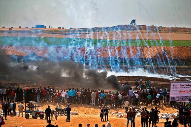 Palstinensische Demonstranten schauen...nnenden Reifen stlich von Gaza-Stadt.  | Foto: AFP