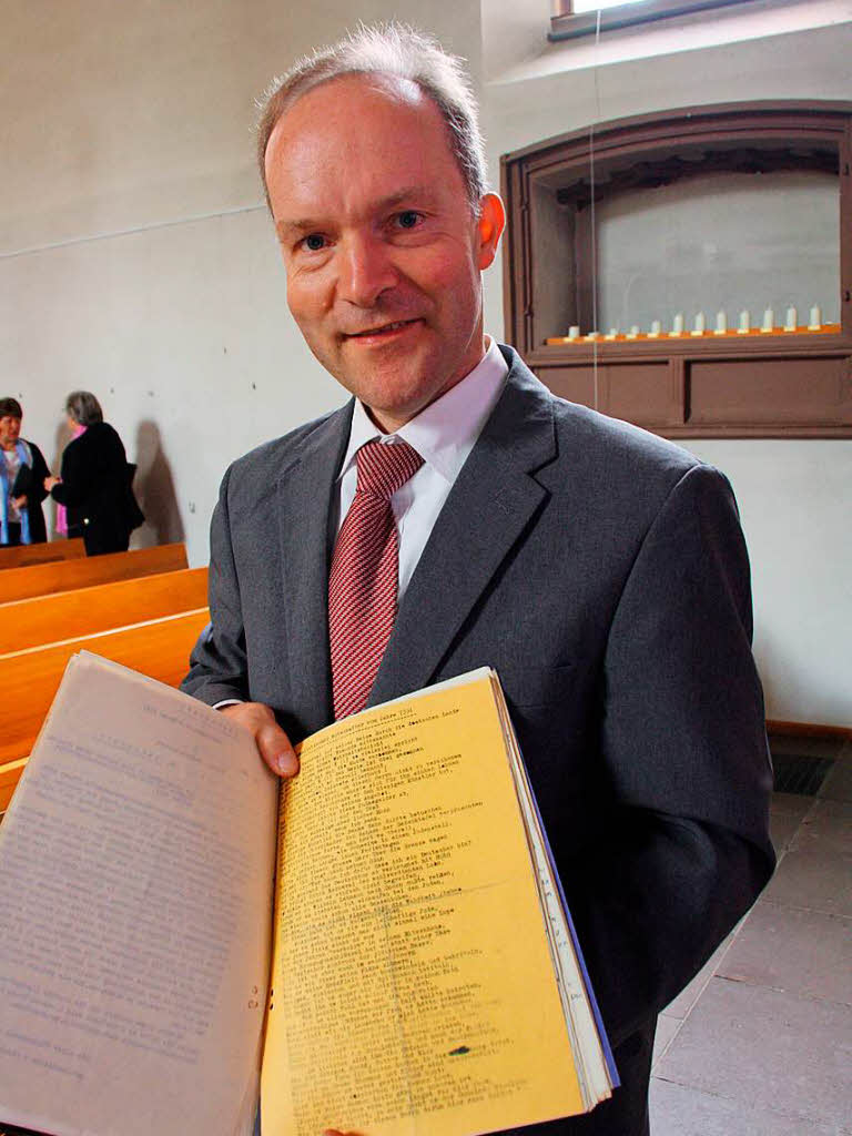 Pfarrer Thomas Herrmann mit Akten aus dem Kirchenarchiv