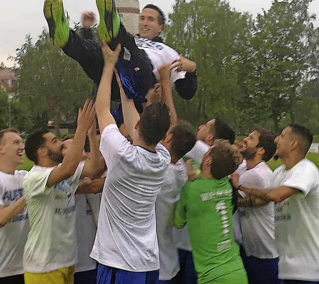 Das Team, schon in Meister-T-Shirts, l...lden Trainer Beni Pfahler hochleben.    | Foto: Joachim Schultis