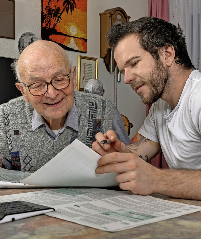 Ein rechtlicher Betreuer geht Unterlagen mit einem Senioren durch.   | Foto: dpa/Albrecht Weier