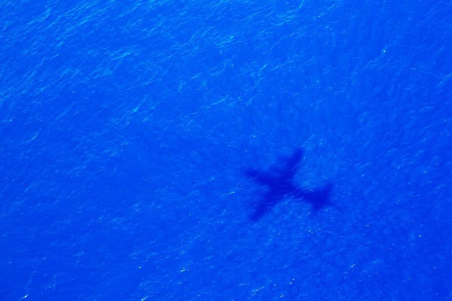 Das Foto zeigt den Schatten eines Flug...m Malaysia Airways Flight MH370 sucht.  | Foto: dpa