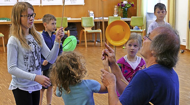 Fritz Klble zeigt  Kindern   Kunststcke der Jongleure.   | Foto: Lena Roser
