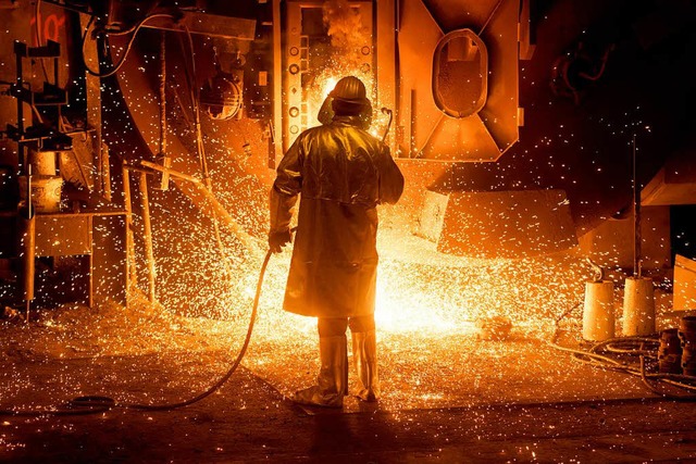 Ein Mitarbeiter in Schutzkleidung arbe...er Salzgitter AG an einer Stahlpfanne.  | Foto: Julian Stratenschulte