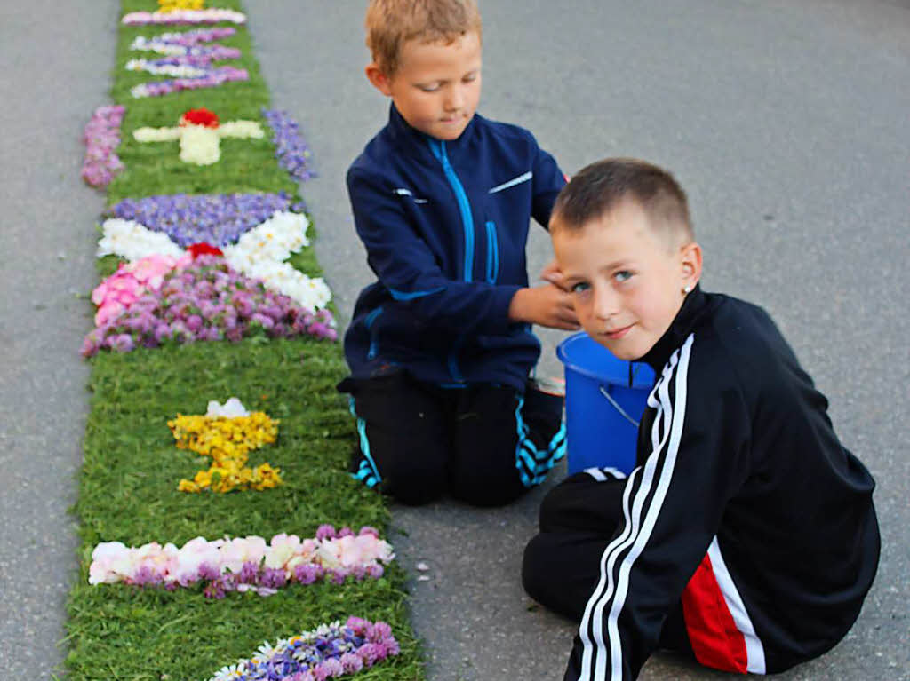 Auch viele Kinder helfen beim Legen des knapp 800 Meter langen Blumenteppichs.
