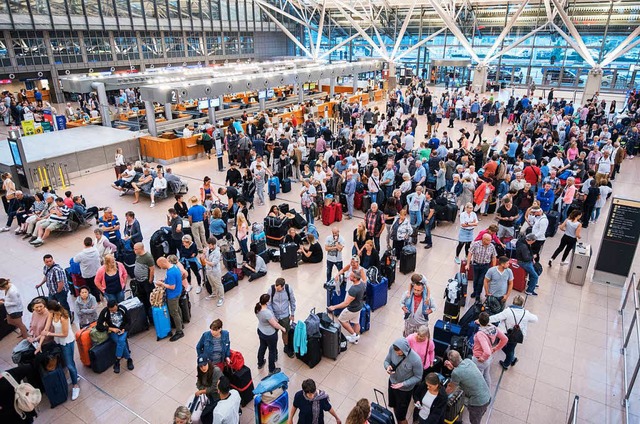 Reisende warten im Helmut-Schmidt-Airp...trieb jetzt wieder aufgenommen werden.  | Foto: dpa