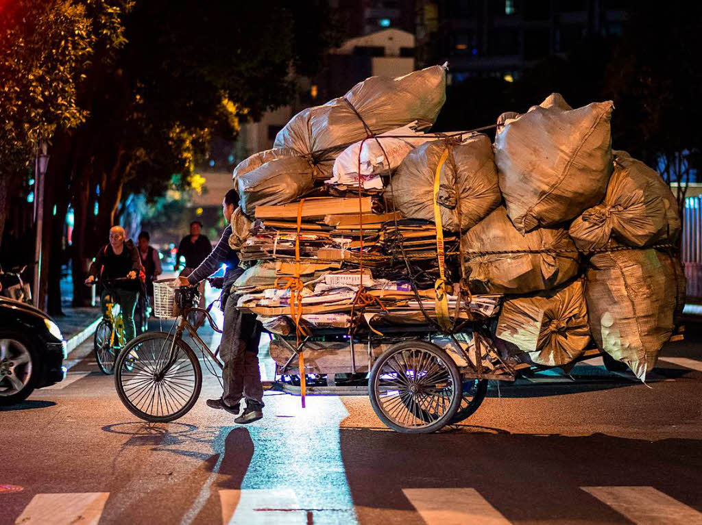 Ein Mllsammler in Shanghai hat sein Dreirad mit Plastik- und Papiermll beladen.