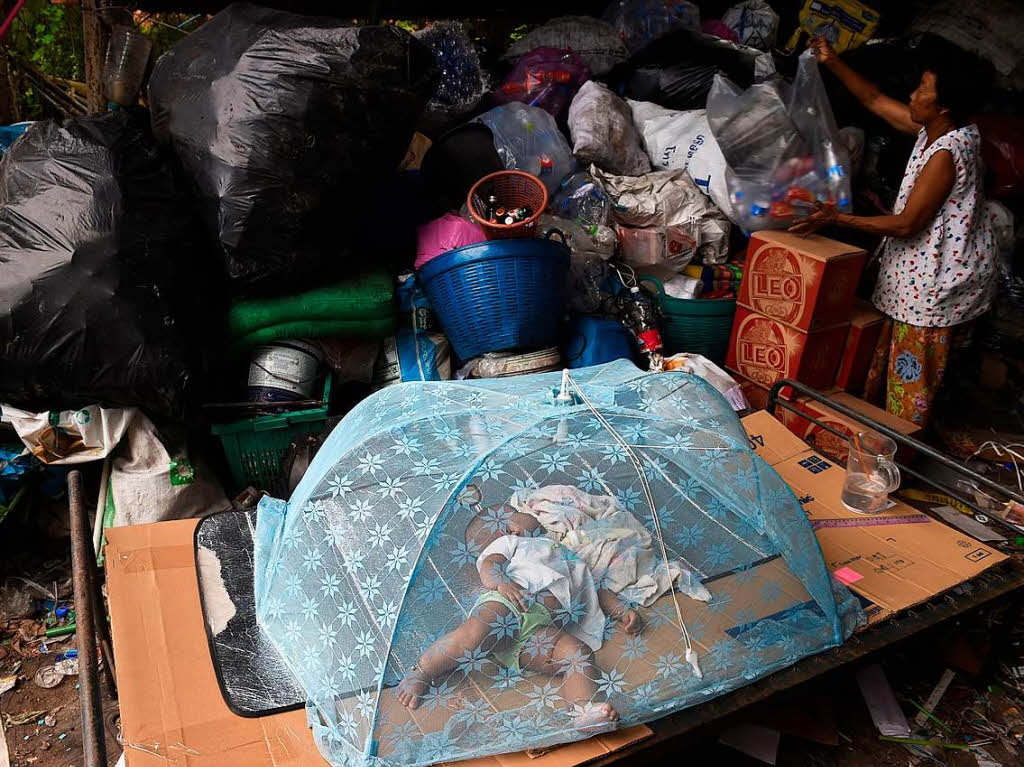 Eine Frau sortiert Plastik und in Bangkok.