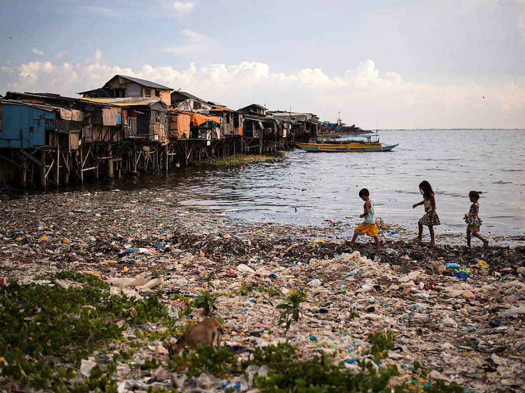 Kinder laufen eine vermllte sBucht in Manila entlang. Etwa acht Millionen Tonnen Plastikmll landen jedes Jahr in den Ozeanen der Welt.