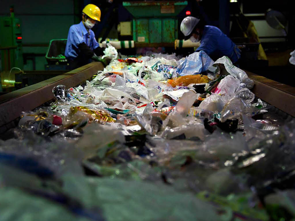 Arbeiter sortieren  im Ichikawa Kankyo Recycling Center nahe Tokyo Mll.