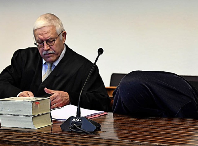Klaus Malek  im Landgericht Freiburg neben einem sich verbergenden Mandanten  | Foto: dpa