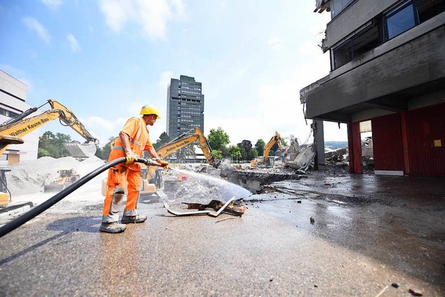 Ein Arbeiter kmpft mit dem Wasserschlauch gegen den Staub.  | Foto: Jonas Hirt