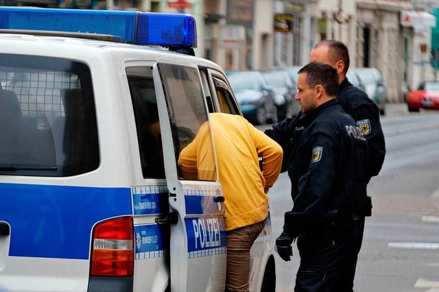 Beamte der Bundespolizei begleiten ein...n in Leipzig zu einem Polizeifahrzeug.  | Foto: dpa