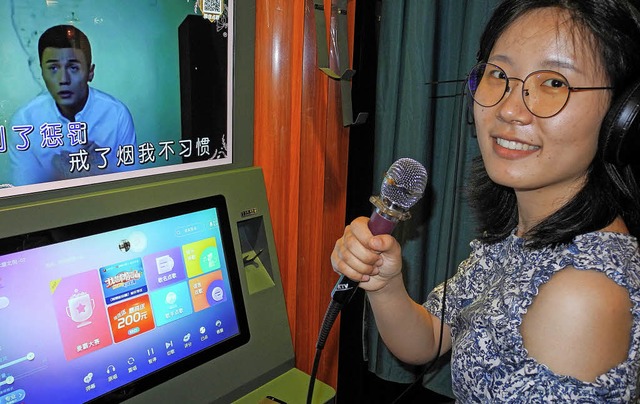 Eine Chinesin sing ein Lied in einer Karaoke-Box   | Foto: dpa