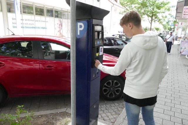 Ein junger Mann bedient den neuen Parkscheinautomaten in der Karlstrae.  | Foto: Elena Borchers