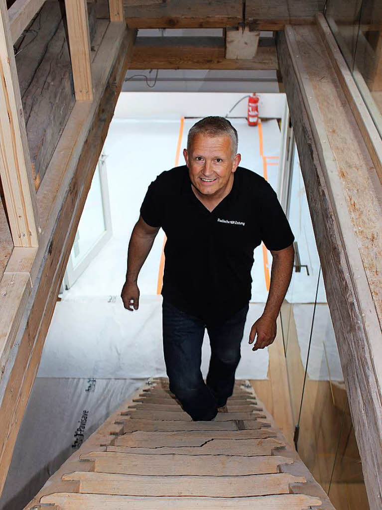 Regionalverlagsleiter Markus Fangmann erklimmt die alten Holzstufen ins Dachgeschoss des Rathauses.