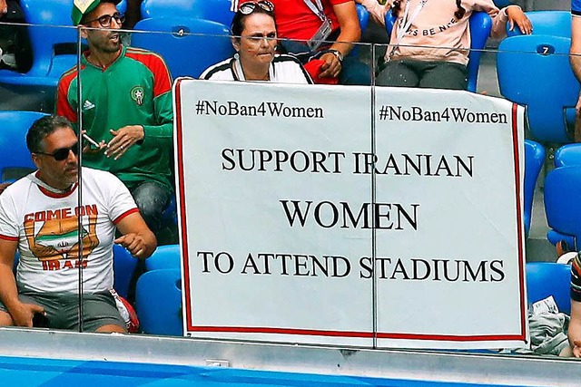 Ein Plakat mit der Aufschrift: Unters...rsten Spiel der Iraner an der Tribne.  | Foto: dpa