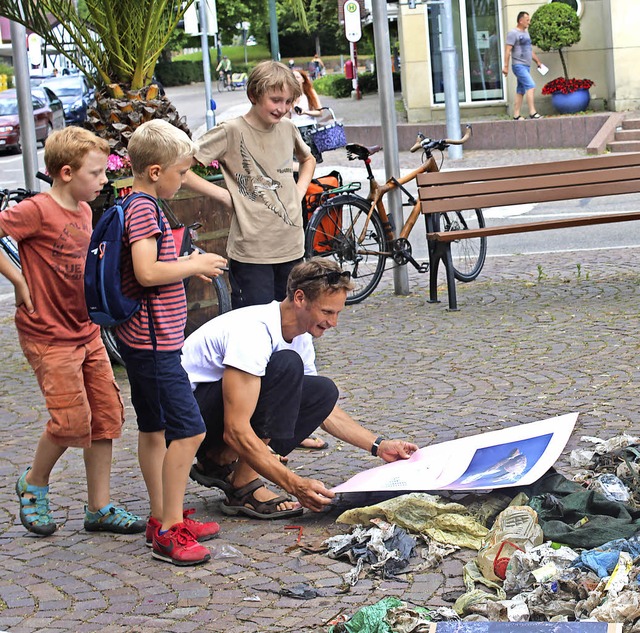 Andr Grabs verteilt mit  Kindern Plastikmll  auf dem  Rathausplatz.   | Foto: Enya Steinbrecher