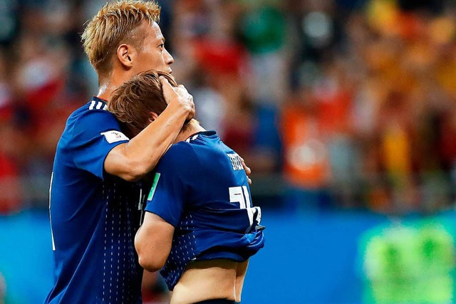 Keisuke Honda (links) aus Japan trste...nach der 3:2 Niederlage auf dem Platz.  | Foto: dpa