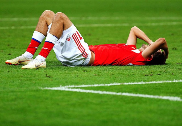 Alexander Jerochin liegt niedergeschlagen auf dem Rasen.  | Foto: dpa