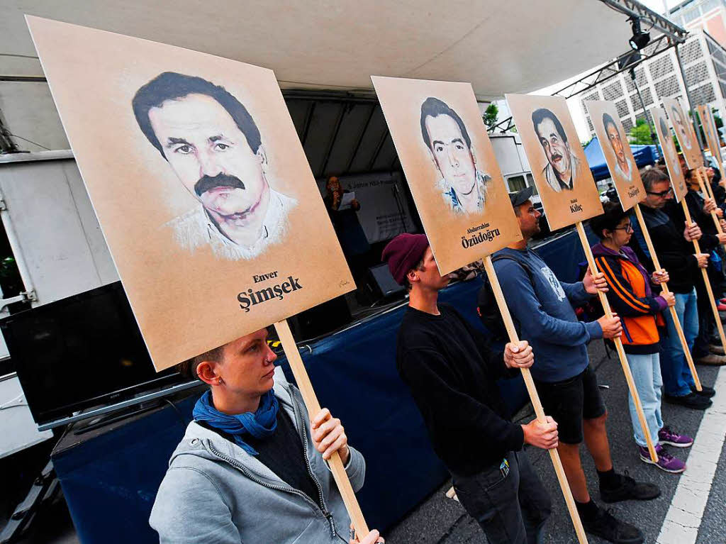 Demonstranten halten bei einer Kundgebung vor dem Oberlandesgericht Schilder mit Abbildung der NSU-Opfer.
