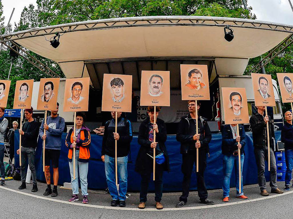 Demonstranten halten bei einer Kundgebung vor dem Oberlandesgericht Schilder mit Abbildung der NSU-Opfer.