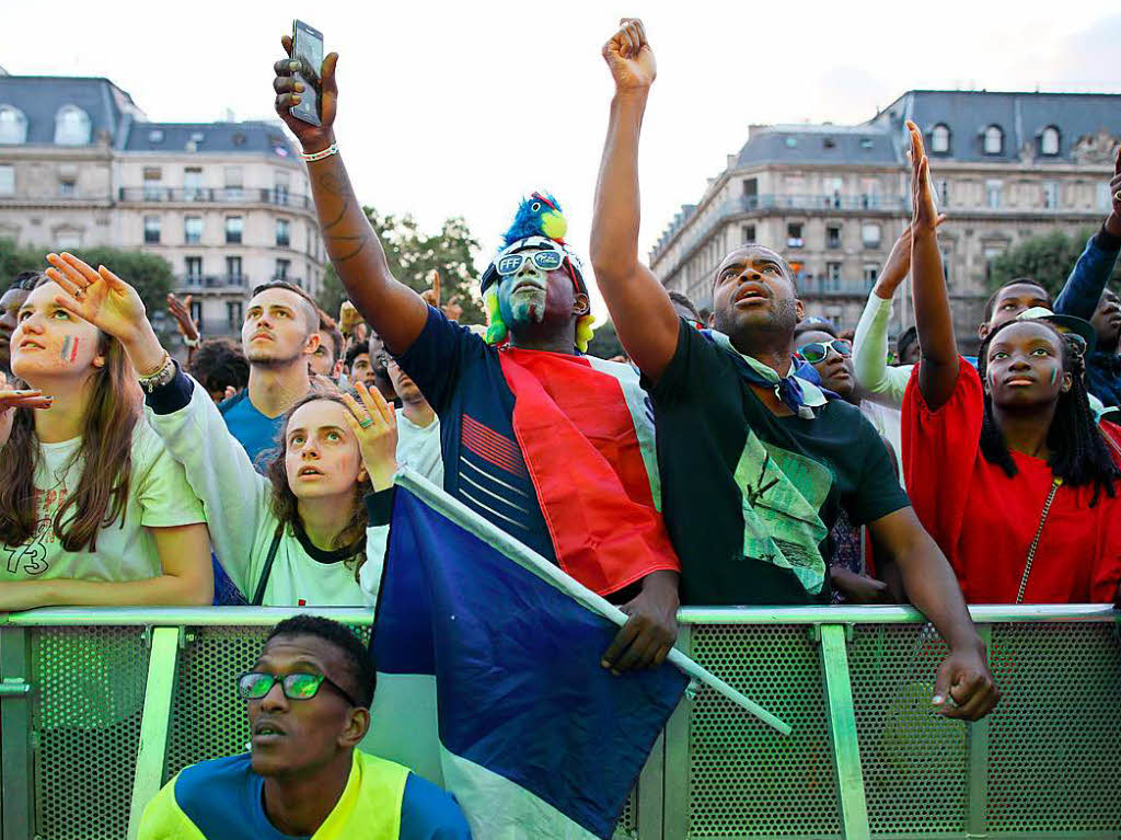 Der Mann mit Kopfschmuck und die Umstehenden in Paris: Alle fieberten auf den Moment des Abpfiffs hin und hofften, dass das 1:0 gegen Belgien hlt...