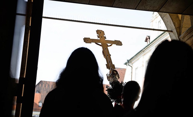 Ein Kreuz wird aus einer Kirche in Rottenburg am Neckar getragen.   | Foto: DPA