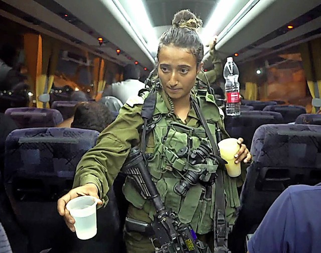 Eine israelische Soldatin verteilt Was...erettete Weihelme und ihre Familien.   | Foto: DPA