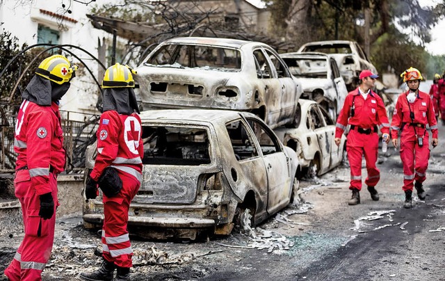 Feuerwehrmnner suchen in den Ruinen von Mati nach weiteren Glutnestern.   | Foto: dpa