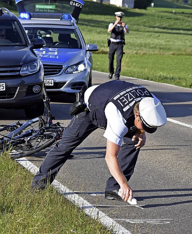 Ein Polizist hlt die Spuren eines Unfalls fest.  | Foto: Martin Ganz
