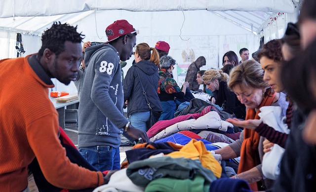 Freiwillige verteilen in Rom Kleidung an Flchtlinge.   | Foto: dpa